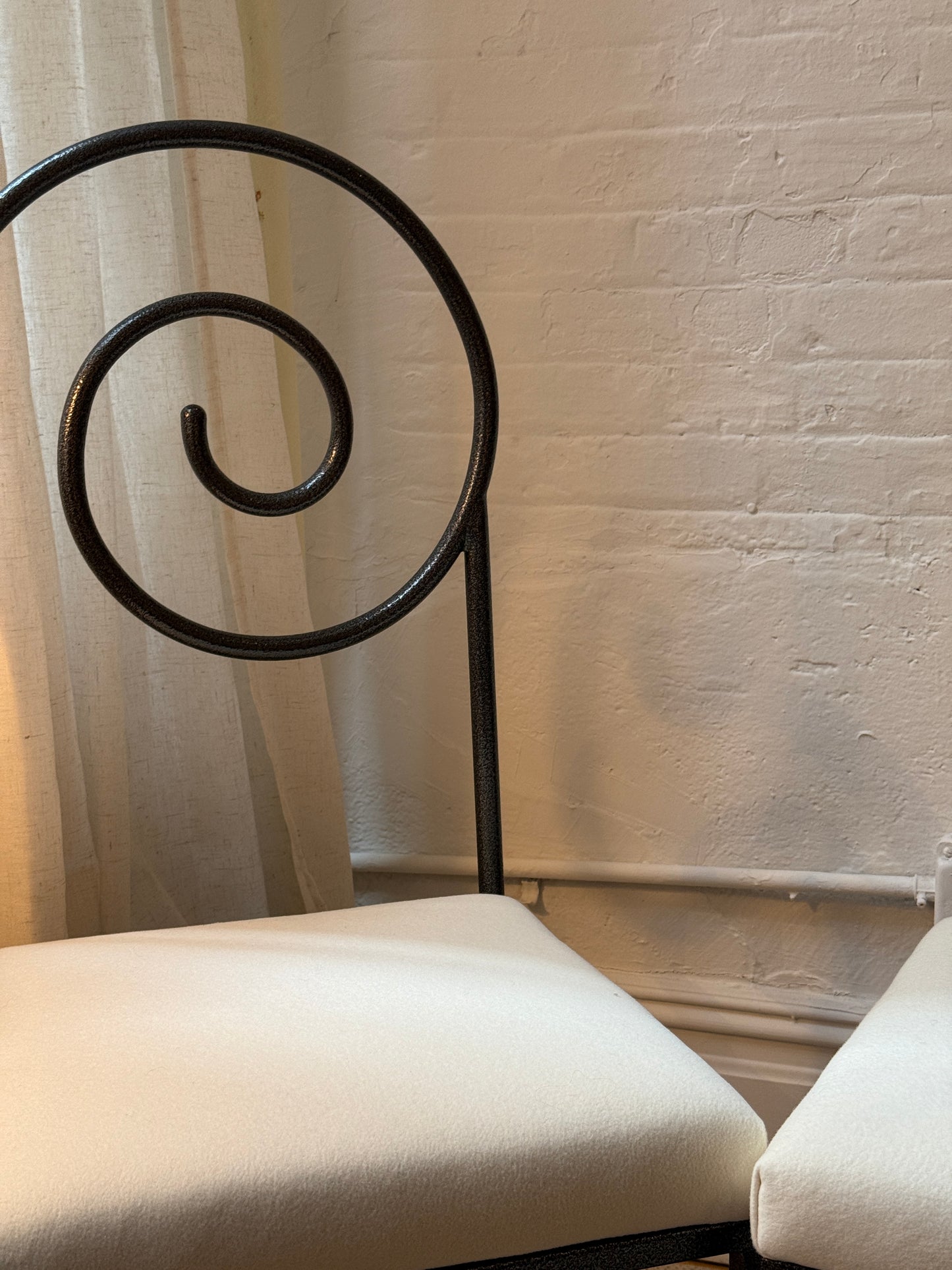 scroll-back iron chairs in cream wool